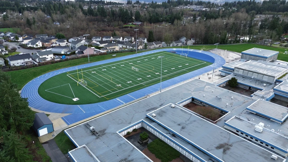 An empty American football field with yard lines viewed from above.